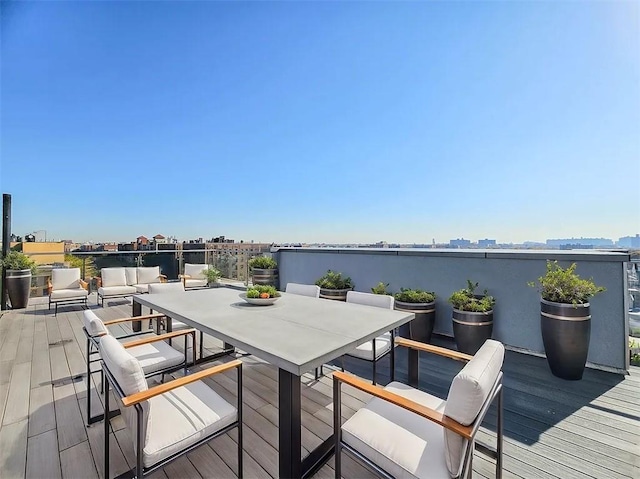 wooden deck featuring outdoor dining area and a city view