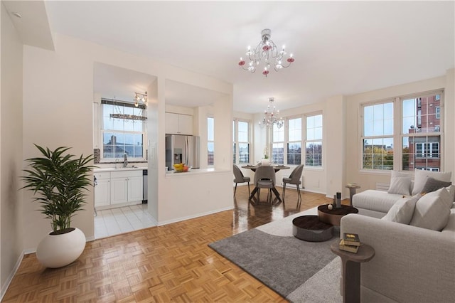 living room with baseboards and a notable chandelier