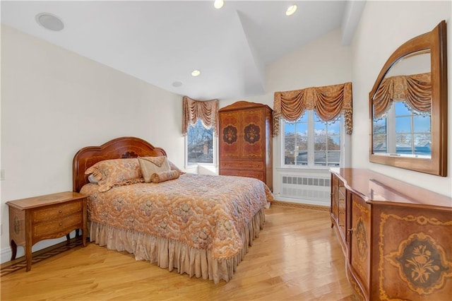 bedroom featuring vaulted ceiling with beams, light hardwood / wood-style flooring, and radiator