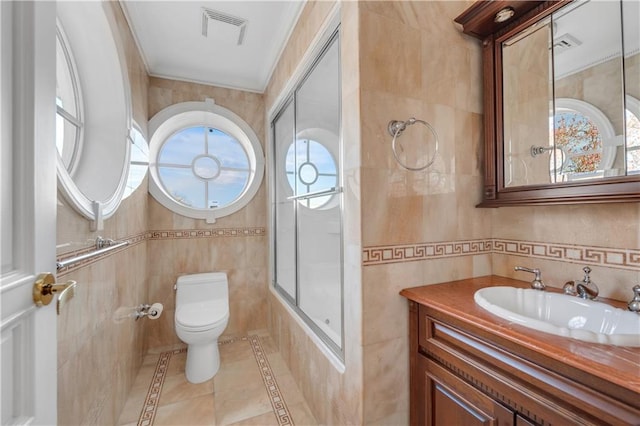 full bathroom with tile patterned floors, tile walls, toilet, vanity, and shower / bathtub combination