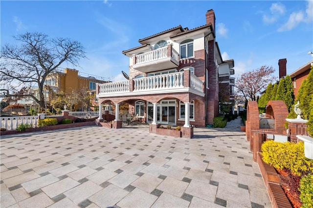 back of house featuring a balcony and a patio