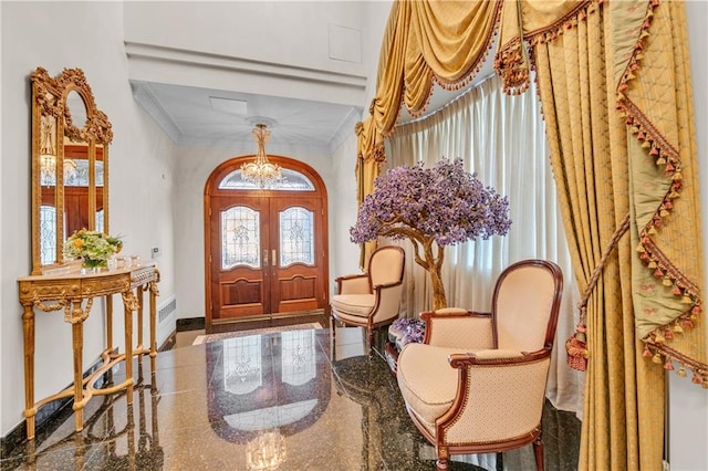 entrance foyer featuring a chandelier, crown molding, and french doors