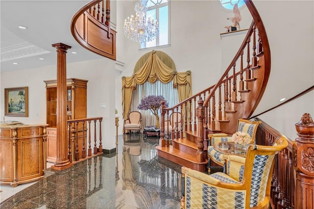 entrance foyer with a chandelier, a high ceiling, and ornate columns