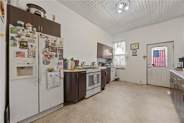 kitchen with gas stove, white fridge with ice dispenser, and dark brown cabinets