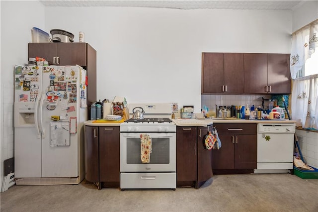 kitchen featuring decorative backsplash, dark brown cabinetry, white appliances, and sink