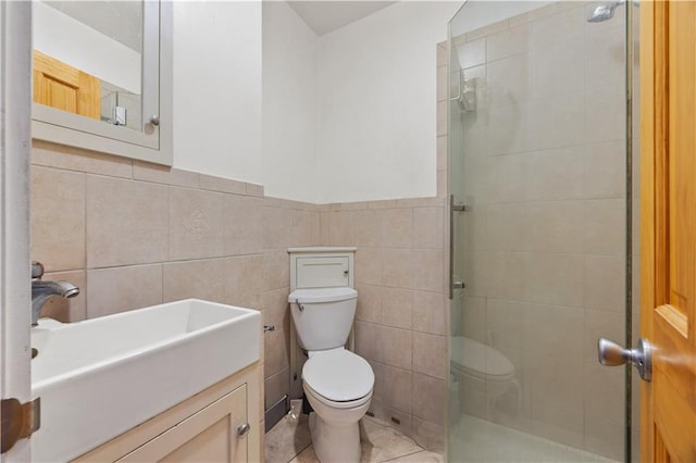 bathroom featuring vanity, tile patterned flooring, toilet, tile walls, and walk in shower