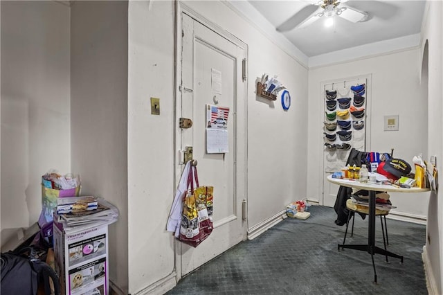 interior space with ceiling fan and dark carpet