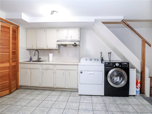 laundry area with light tile patterned floors, sink, and washing machine and clothes dryer