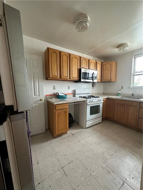 kitchen featuring white range with gas cooktop and sink