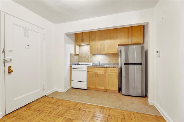 35 Oliver St Unit 1D, Brooklyn, NY 11209 - kitchen with freestanding refrigerator, white gas range, a sink, decorative backsplash, and baseboards