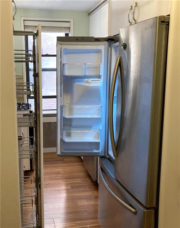 interior space featuring dark hardwood / wood-style flooring and stainless steel fridge