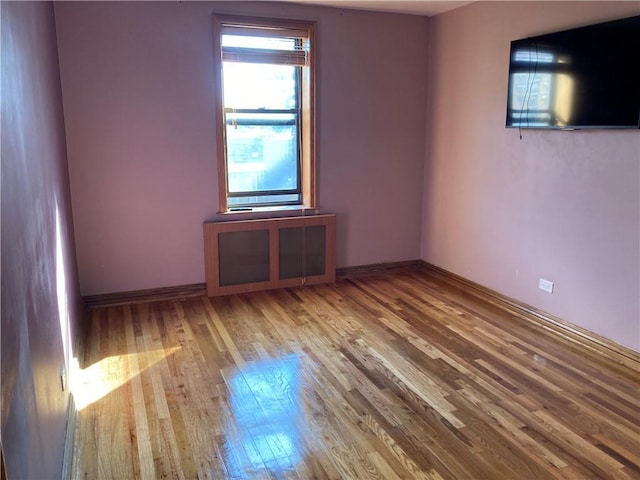 empty room with baseboards and wood finished floors