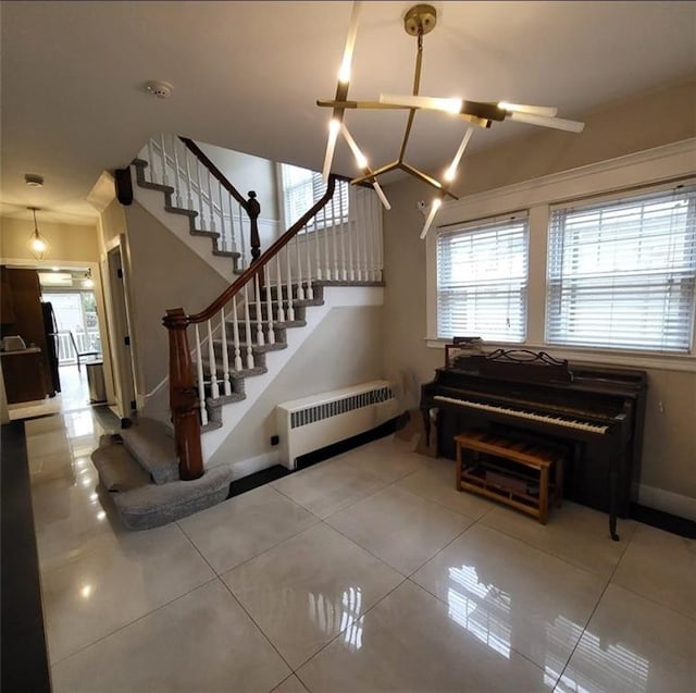 interior space featuring baseboards, an inviting chandelier, radiator, and tile patterned flooring