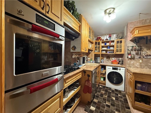 kitchen featuring washer / dryer, sink, stainless steel double oven, black gas cooktop, and backsplash