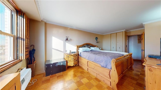 bedroom with ornamental molding and light parquet flooring