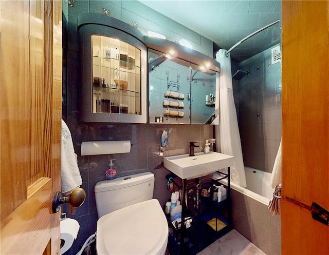 full bathroom featuring tasteful backsplash, sink, tile walls, toilet, and shower / bathtub combination with curtain