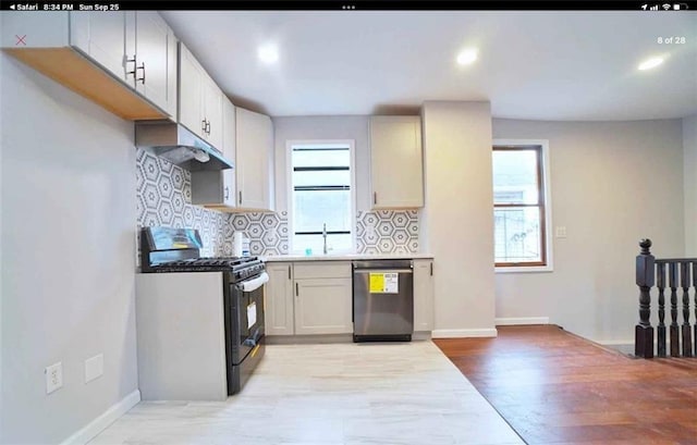 kitchen with backsplash, stainless steel appliances, light hardwood / wood-style floors, and sink