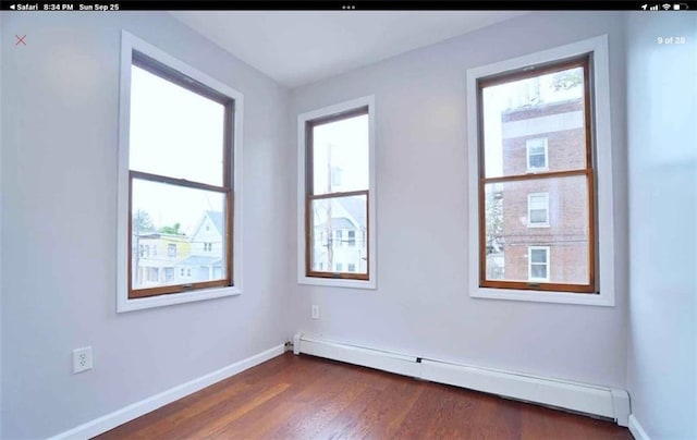 spare room featuring dark hardwood / wood-style flooring and baseboard heating