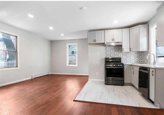 kitchen featuring plenty of natural light, stainless steel stove, light hardwood / wood-style flooring, and black dishwasher