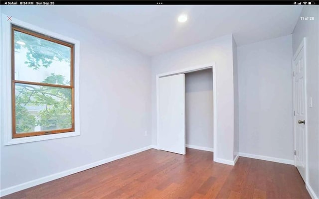 unfurnished bedroom featuring a closet and dark hardwood / wood-style floors