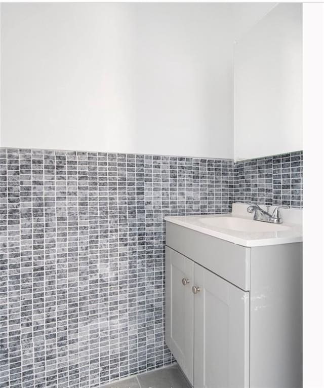 bathroom featuring vanity and tile walls