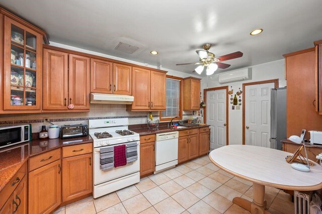 kitchen featuring white appliances, ceiling fan, light tile patterned flooring, decorative backsplash, and an AC wall unit