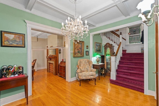 sitting room featuring stairway, coffered ceiling, wood finished floors, and beamed ceiling