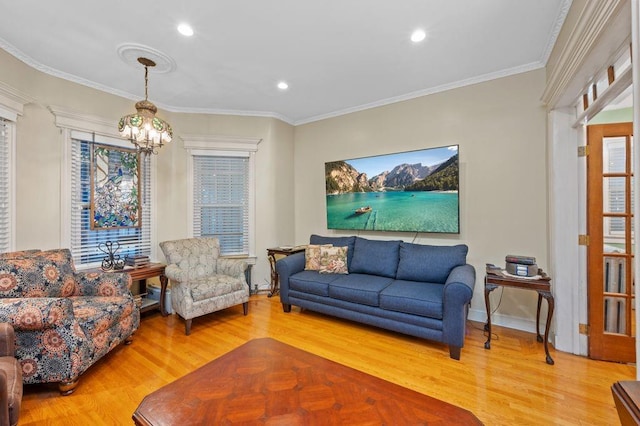 living area featuring a notable chandelier, ornamental molding, and wood finished floors