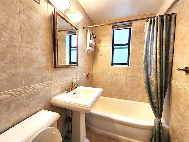 bathroom featuring tile walls, shower / bath combination with curtain, and toilet