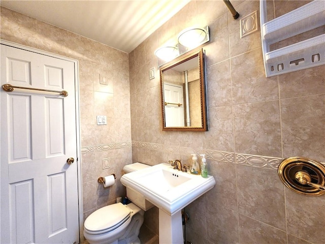 bathroom featuring tile walls and toilet