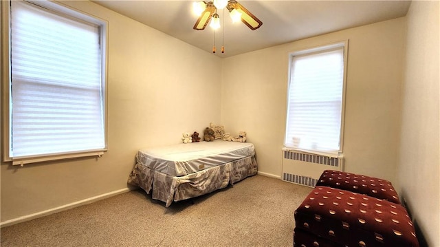 bedroom featuring radiator, ceiling fan, and carpet flooring