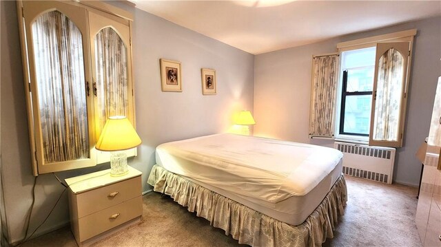 bedroom featuring french doors, radiator heating unit, and carpet floors