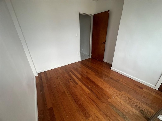 unfurnished room with baseboards and wood finished floors