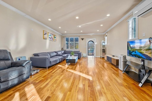 living room featuring a wall unit AC, ornamental molding, and light hardwood / wood-style floors