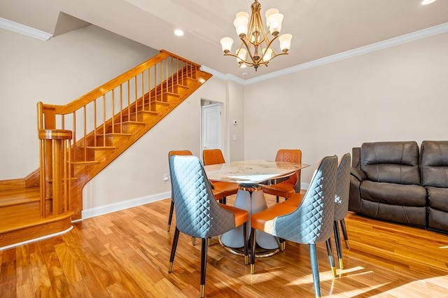 dining room with light hardwood / wood-style flooring, ornamental molding, and a chandelier