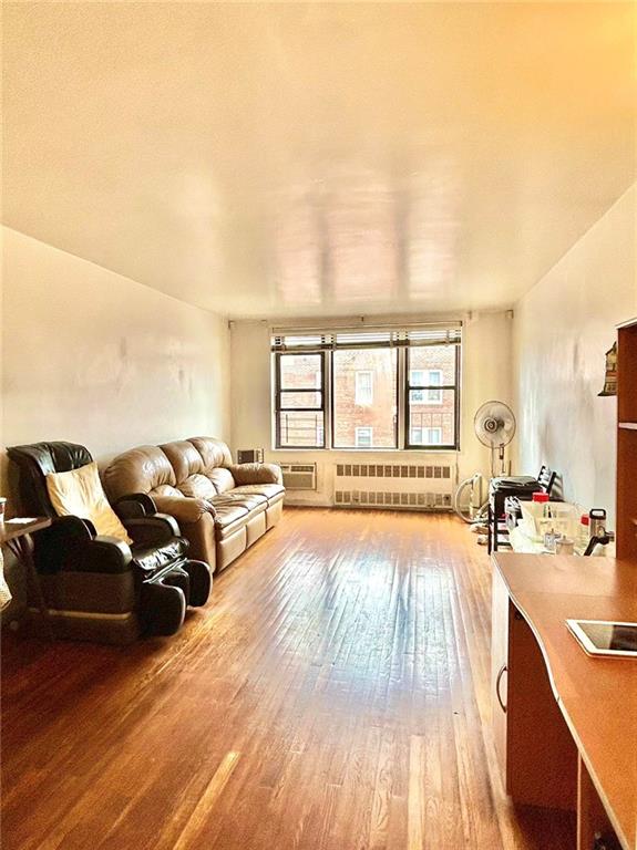 living room with radiator heating unit and hardwood / wood-style floors