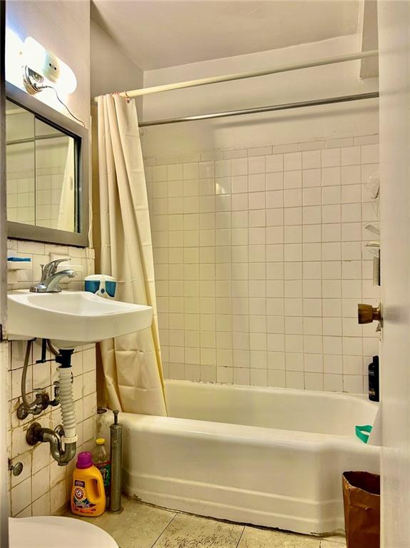 full bathroom featuring tile patterned floors, sink, shower / bath combination with curtain, and toilet