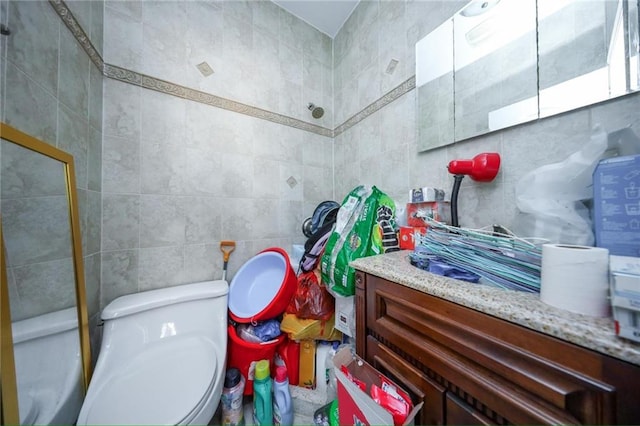 bathroom with tile walls, toilet, and vanity