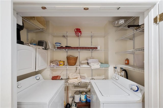 clothes washing area featuring washer / clothes dryer and cabinets