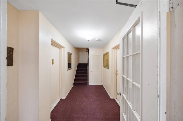 hall featuring carpet flooring, stairway, and baseboards