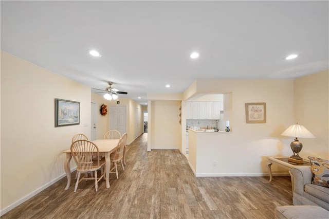 dining area with ceiling fan and light wood-type flooring