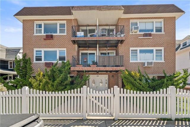 multi unit property featuring a fenced front yard and brick siding