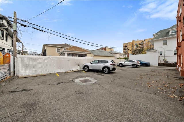 uncovered parking lot featuring fence