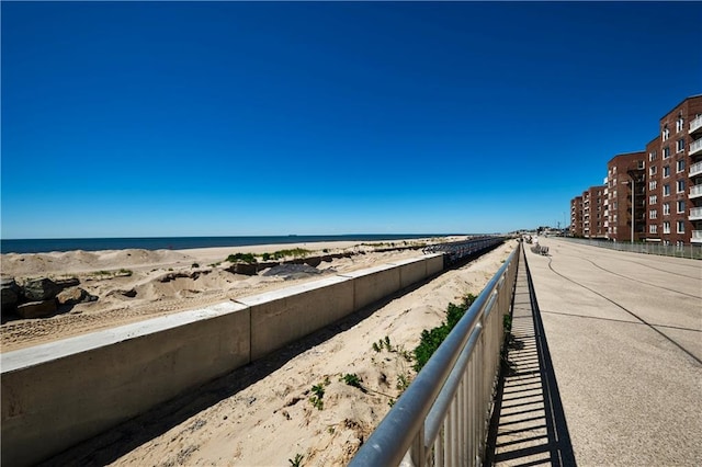 balcony with a water view and a view of the beach