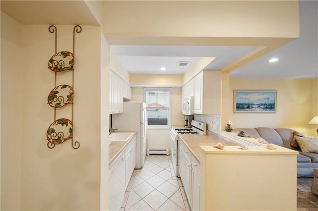 kitchen with light tile patterned floors, white appliances, backsplash, white cabinets, and a baseboard radiator