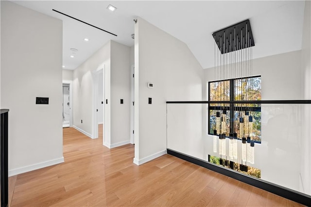 hallway with vaulted ceiling, recessed lighting, light wood-type flooring, and baseboards