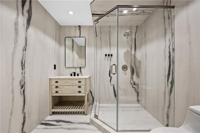 bathroom with a marble finish shower, vanity, and toilet