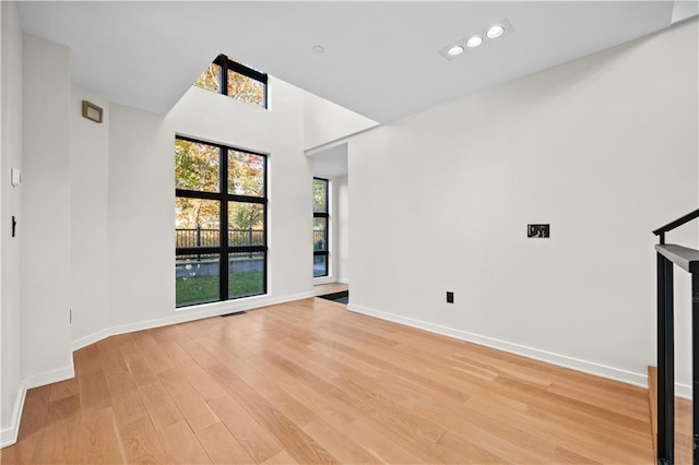 unfurnished living room with light wood-type flooring, visible vents, baseboards, and recessed lighting