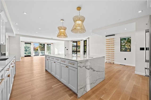 kitchen with a wealth of natural light, recessed lighting, open floor plan, and light wood-style flooring