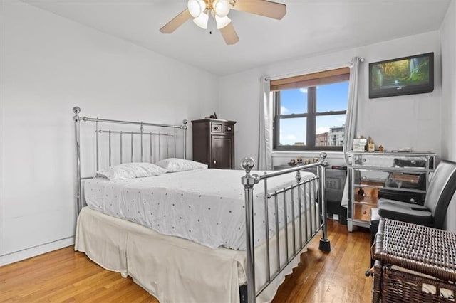 bedroom with a ceiling fan and wood finished floors